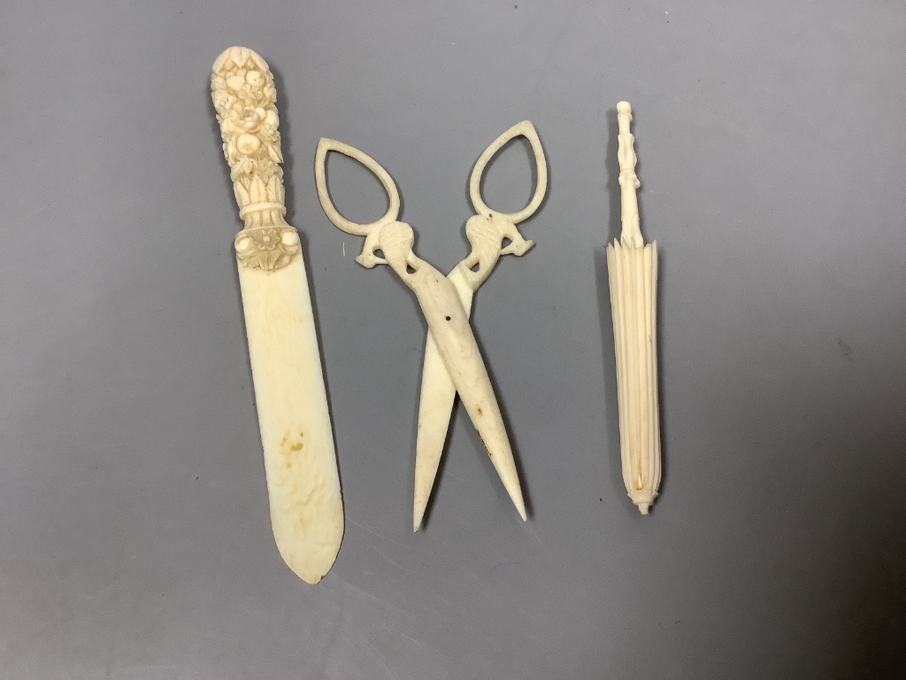 A group of early 19th/20th century ivory including a spinning top and a parasol needle case